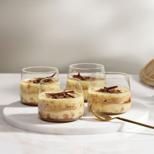 Die Desserts in den Gläsern zeigen eine ansprechende Schichtung aus Creme und Keks, verziert mit feinen Schokoladenraspeln.