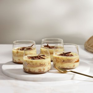 Die Desserts in den Gläsern zeigen eine ansprechende Schichtung aus Creme und Keks, verziert mit feinen Schokoladenraspeln.