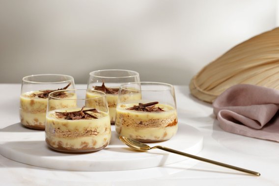 Die Desserts in den Gläsern zeigen eine ansprechende Schichtung aus Creme und Keks, verziert mit feinen Schokoladenraspeln.