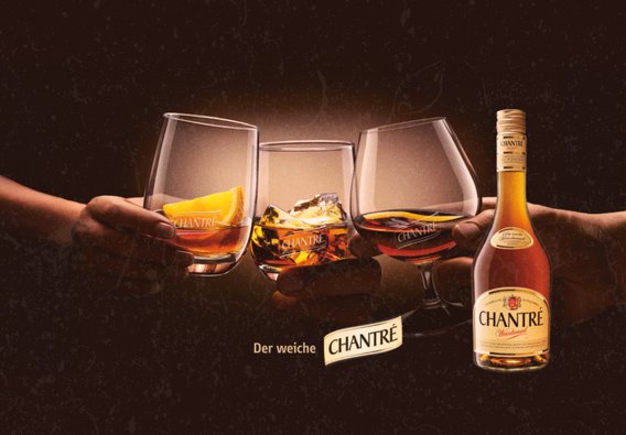 Drei Gläser mit CHANTRÉ-Getränken werden von Händen gehalten, während ein Flasche des Getränks im Hintergrund sichtbar ist.