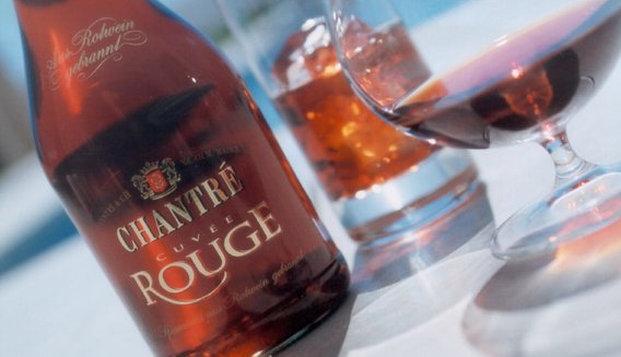 Die Flasche Chantre Rouge ist gut sichtbar, während ein Glas mit Wein und ein weiteres mit Eis im Hintergrund stehen.