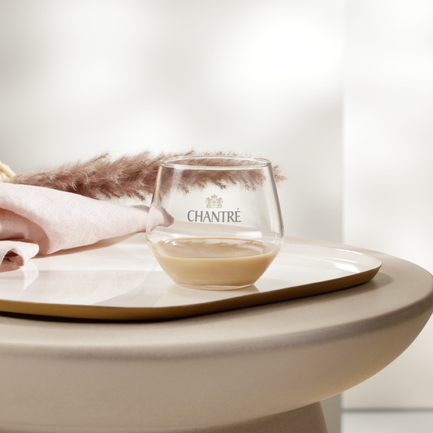 Ein eleganter Tisch mit einem Glas, einer Serviette und dekorativen Pampasgrassträußen in einem hellen Raum.